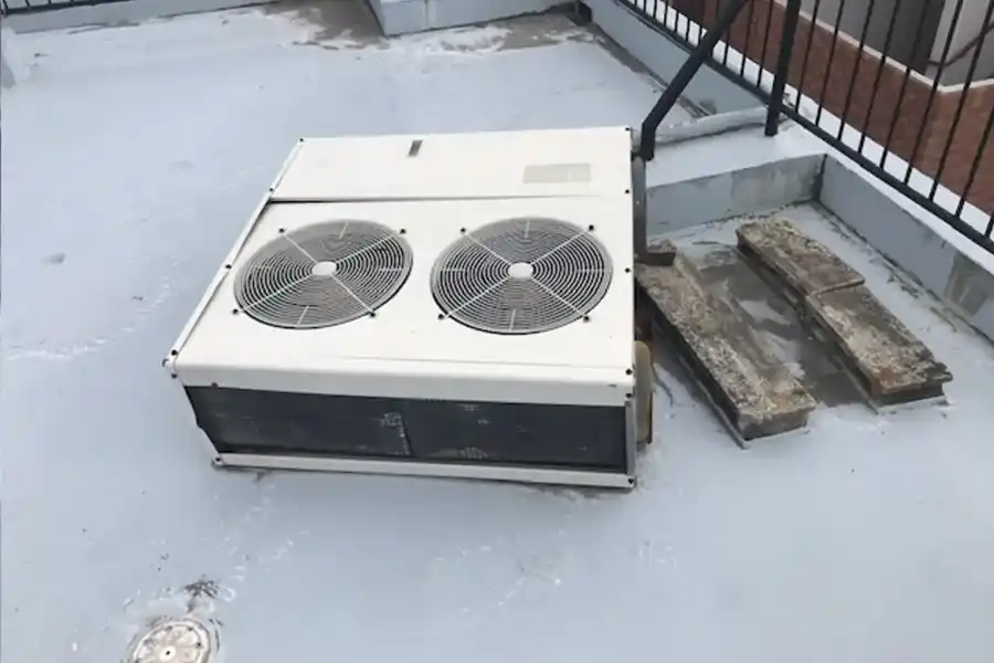 台風の強風で室外機が倒れ、防水層が傷ついた